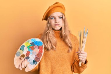 Kafkasyalı güzel bir kız elinde boya fırçası ve komik suratlı yanakları şişiren bir ressam paleti tutuyor. Ağzı havayla şişer, havayı yakalar.. 