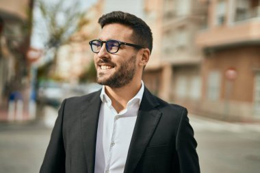 Genç İspanyol işadamı gülümseyerek şehirde mutlu mesut duruyor..