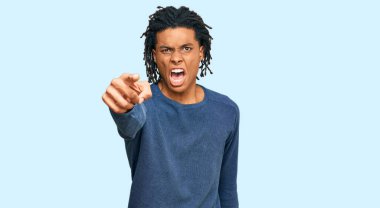 Sıradan bir kazak giyen genç Afrikalı Amerikalı adam kameraya kızgın ve sinirli bir şekilde bakıyor. 