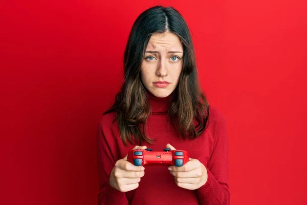 Young Brunette Woman Playing Video Game Holding Controller Skeptic Nervous — Stock Photo, Image