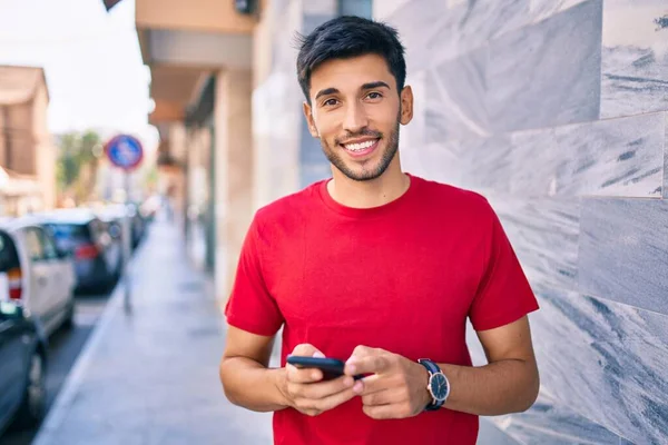 Joven Latino Sonriendo Feliz Usando Smartphone Caminando Por Ciudad —  Fotos de Stock