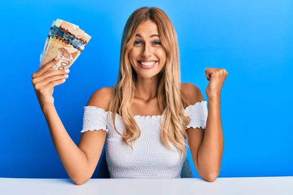 Beautiful Blonde Young Woman Holding Canadian Dollars Screaming Proud Celebrating — Stock Photo, Image