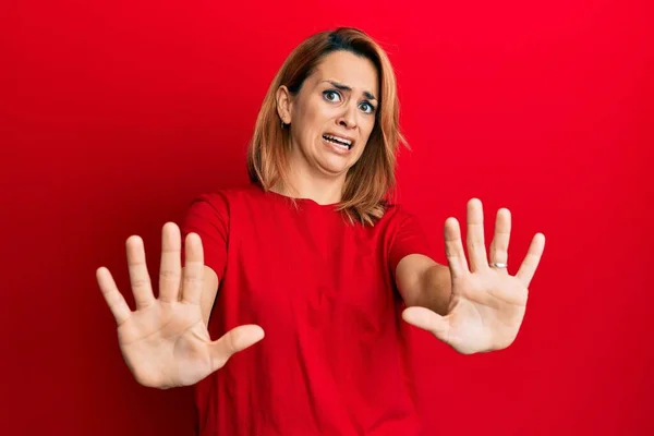 Hispanic Ung Kvinna Bär Casual Röd Shirt Rädd Och Skräckslagen — Stockfoto