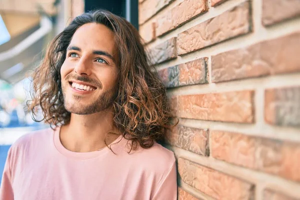 Jovem Hispânico Sorrindo Feliz Olhando Para Lado Inclinado Parede — Fotografia de Stock