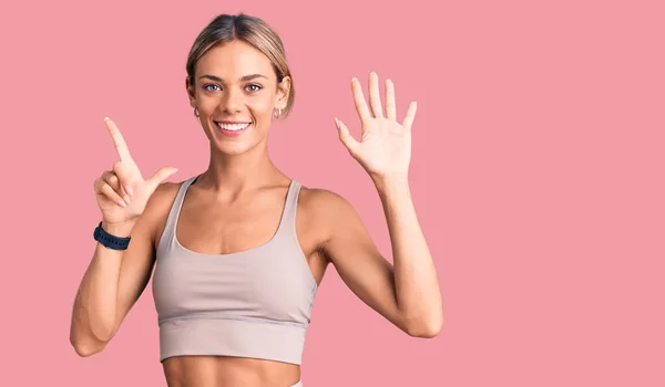 Mooie Kaukasische Vrouw Draagt Sportkleding Tonen Wijzen Met Vingers Nummer — Stockfoto