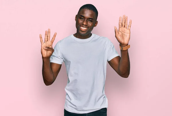 티셔츠를 자신감 행복하게 웃으면서 손가락으로 가리키는 아프리카계 — 스톡 사진
