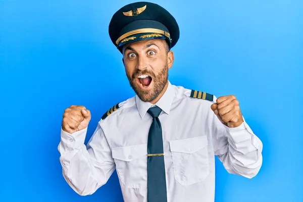 Przystojny Mężczyzna Brodą Mundurze Pilota Samolotu Świętuje Zaskoczony Zdumiony Sukcesem — Zdjęcie stockowe