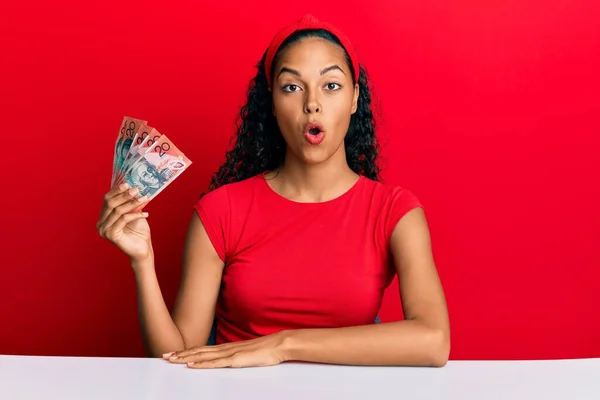 Young African American Girl Holding Australian Dollars Sitting Table Scared — Stock Photo, Image