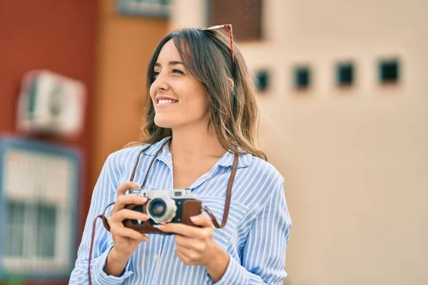 若いですヒスパニック系観光客女性笑顔幸せな使用ヴィンテージカメラによって街 — ストック写真