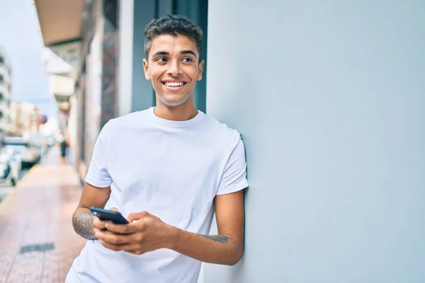 Jong Latijn Man Glimlachen Blij Met Behulp Van Smartphone Leunend — Stockfoto