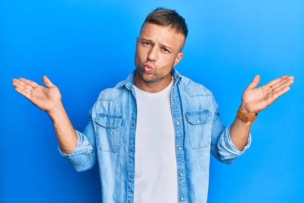 Sıradan bir kot ceket giyen yakışıklı kaslı adam habersiz ve kolları açık, hiçbir fikrim yok ve şüpheli bir yüz var.. 