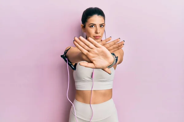 Mujer Hispana Joven Usando Ropa Gimnasio Usando Auriculares Expresión Rechazo — Foto de Stock