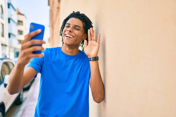 Młody Afroamerykanin Wykonuje Wideo Rozmowy Pomocą Smartfona Opierając Się Ścianie — Zdjęcie stockowe