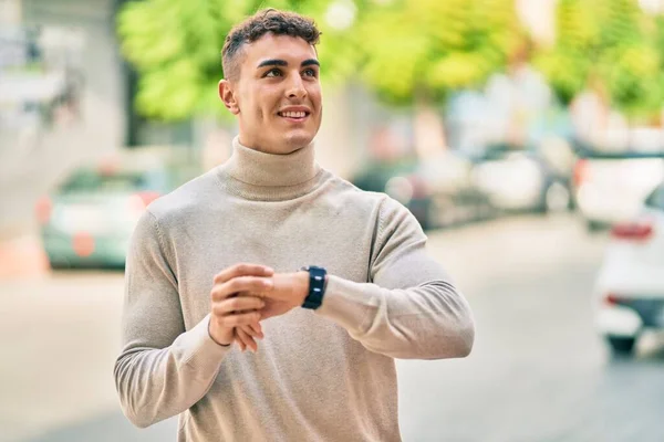 Joven Hombre Hispano Sonriendo Feliz Usando Reloj Ciudad — Foto de Stock