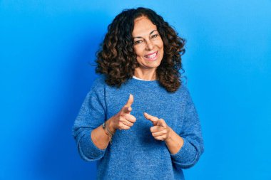 Orta yaşlı, sıradan kıyafetler giyen, mutlu ve komik yüzlü bir kadın. iyi enerji ve titreşimler. 