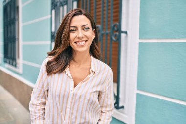 Genç İspanyol kadın gülümseyerek şehirde mutlu mesut yürüyor..