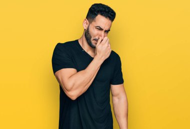 Sakallı, sıradan siyah tişörtlü, pis ve iğrenç bir koku alan, nefesini burnunda tutan İspanyol bir adam. Kötü kokuyor. 