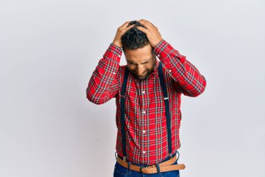 Sakallı yakışıklı, hippi görünümlü, baş ağrısı çeken, çaresiz ve stresli bir adam. Çünkü acı ve migren ağrısı var. Eller başının üstünde.. 