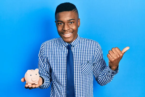Młody Afroamerykanin Ubraniu Biznesowym Trzymający Świnkę Kciukiem Górze Uśmiechnięty Otwartymi — Zdjęcie stockowe
