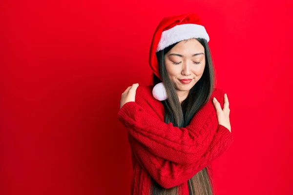 Νεαρή Κινέζα Που Φοράει Χριστουγεννιάτικο Καπέλο Αγκαλιάζει Τον Εαυτό Της — Φωτογραφία Αρχείου