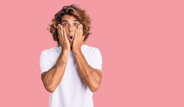 Günlük beyaz tişört giyen genç İspanyol adam korkmuş ve şok olmuş, şaşırmış ve şaşırmış bir yüz ifadesi takınmıştı. 