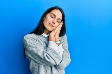 Latin kökenli genç bir kadın gündelik kıyafetler giyip uyuyordu. Yorgun düşler görüyordu. Elleriyle poz veriyordu.. 