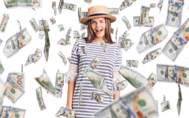 Güzel beyaz kadın, yaz şapkası takmış, kameraya seksi bir ifadeyle bakıyor, neşeli ve mutlu bir yüzle..