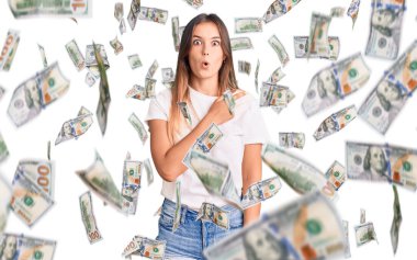 Gayri resmi beyaz tişört giyen güzel beyaz kadın parmaklarını yana çevirerek şaşırdı, ağzı açık hayret içinde kaldı..