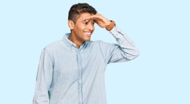 Genç, yakışıklı, Afro-Amerikan bir adam. Günlük kıyafetler giyiyor. Çok mutlu ve gülümsüyor. arama kavramı. 