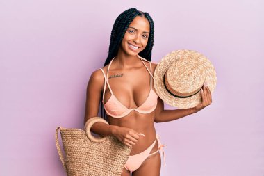 Güzel İspanyol kadın bikini ve şapkalı mutlu ve havalı bir gülümsemeyle gülümsüyor. diş gösterme. 