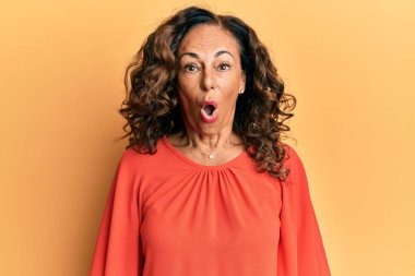 Orta yaşlı İspanyol kadın gündelik giysiler giyiyor. Şaşırmak için ağzı açık kalmış, korkmuş ve şaşırmış. İnanmayan yüz. 