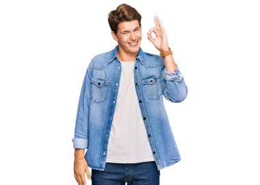 Sıradan kot ceket giyen yakışıklı beyaz adam gülümseyerek el ve parmaklarıyla 