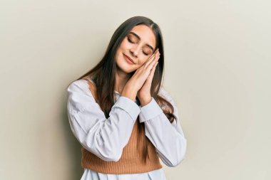 Güzel, esmer, sıradan giysiler giyen, yorgun uyuyan, hayal kuran ve elleriyle poz veren ve gözleri kapalı gülümseyen bir kadın.. 