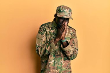 Asker üniforması giyen genç Afro-Amerikan adam gülüyor ve utanıyor kıkırdıyor ağızlarını ellerle, dedikoduyla ve skandal konseptiyle kapatıyor. 