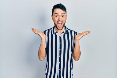 Sıradan kıyafetler giyen genç İspanyol adam çılgın ve başarıyı kollarını kaldırıp heyecanla haykırarak kutluyor. Kazanan konsept 