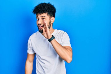 Sakallı, beyaz tişörtlü, ağzı açık genç bir Arap adam. Gizli söylentiler yayıyor, kötü niyetli konuşmalar fısıldıyor. 