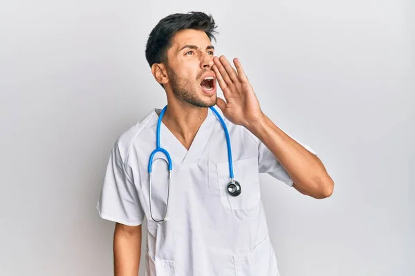 Joven Hombre Guapo Vistiendo Uniforme Médico Estetoscopio Gritando Gritando Fuerte — Foto de Stock