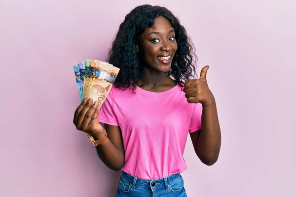 Krásná Africká Mladá Žena Drží Kanadské Dolary Úsměvem Šťastný Pozitivní — Stock fotografie