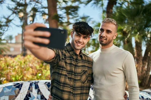 在城市里 一对年轻的同性恋夫妇一边笑着一边用智能手机自杀 — 图库照片