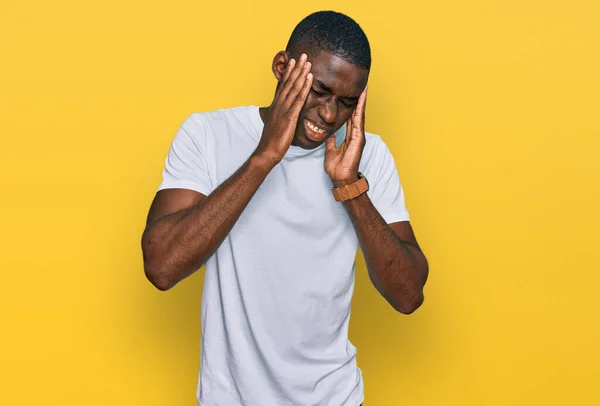 年轻的非洲裔美国人穿着宽松的白色T恤 头戴双手 因为压力头疼 偏头痛 — 图库照片