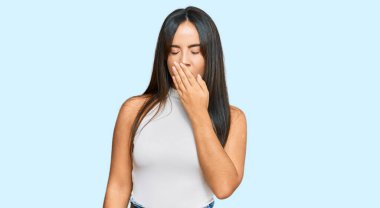 Gündelik kıyafetler giyen genç, güzel İspanyol kız ağzıyla ağzını kapatmaktan sıkılmış. Huzursuz ve uykulu.. 