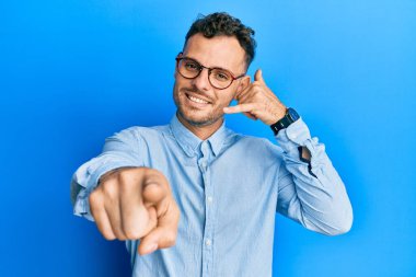 Günlük kıyafetler ve gözlük takan genç İspanyol adam gülümsüyor telefonda konuşuyor ve seni işaret ediyor. Ara beni.. 