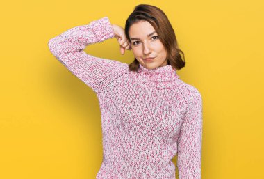 Beyaz, yün kazak giyen genç bir kız. Kol kası gösteren güçlü, kendinden emin ve gururlu biri. 