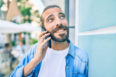 Ortadoğulu genç adam şehirdeki akıllı telefondan konuşuyor..