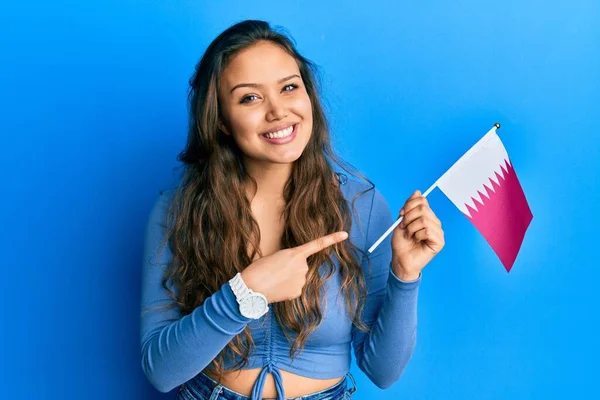 Young Hispanic Girl Holding Qatar Flag Smiling Happy Pointing Hand — ストック写真