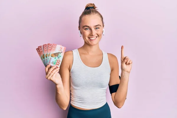 Beautiful Blonde Sport Woman Holding 100 New Zealand Dollars Banknote — Stock Photo, Image