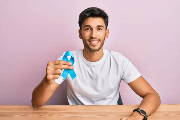 Jovem Homem Bonito Segurando Fita Azul Olhando Positivo Feliz Sorrindo — Fotografia de Stock