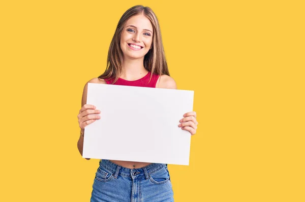 Jovem Bela Mulher Loira Segurando Banner Vazio Branco Olhando Positivo — Fotografia de Stock