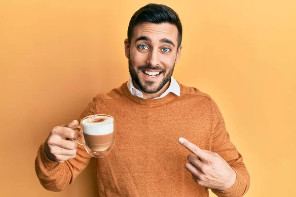 Νεαρός Ισπανός Κρατώντας Καφέ Χαμογελώντας Χαρούμενος Δείχνοντας Χέρι Και Δάχτυλο — Φωτογραφία Αρχείου