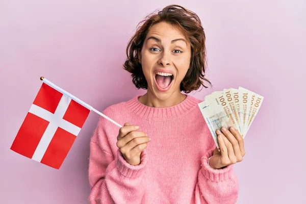 若いですブルネット女性保持ノルウェーのフラグとクローン銀行券祝うクレイジーと驚きのために成功とともにオープン目叫んで興奮 — ストック写真